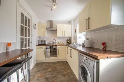 a kitchen with white cabinets and a washing machine at Lena House in Glasgow