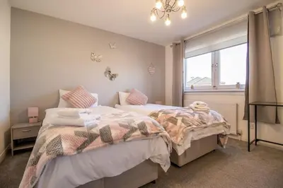 a bedroom with two beds and a window at Lena House in Glasgow