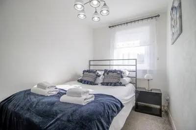 a bedroom with a large bed with towels on it at Lena House in Glasgow