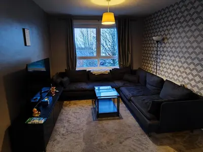 a living room with a couch and a table at Modern 2-in-1 Retreat for Groups in Port Glasgow