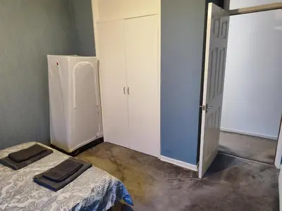 a small room with a bed and a refrigerator at Modern 2-in-1 Retreat for Groups in Port Glasgow