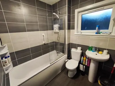 a bathroom with a sink and a toilet and a shower at Modern 2-in-1 Retreat for Groups in Port Glasgow