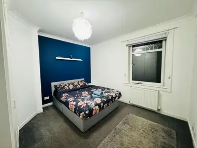 a bedroom with a bed and a window at Blue Heaven Apartments in Edinburgh
