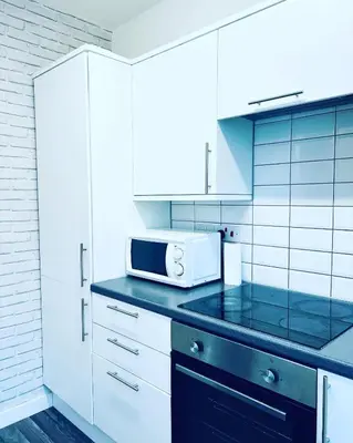 a kitchen with white cabinets and a microwave on a counter at Blue Heaven Apartments in Edinburgh