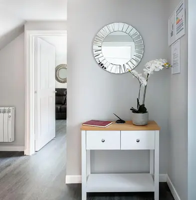 a white table with a mirror and a plant on it at Castle Street Apartments - Luxury Ettrick Apartment in Rothesay