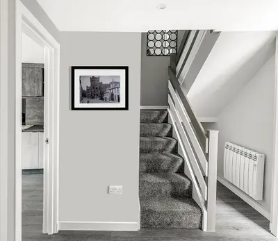 a staircase in a house with a picture on the wall at Castle Street Apartments - Luxury Ettrick Apartment in Rothesay