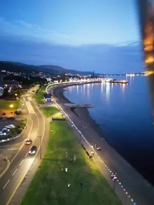 a view of a road next to a body of water at Quiet Street's Flat with free Parking near Town Centre in Largs