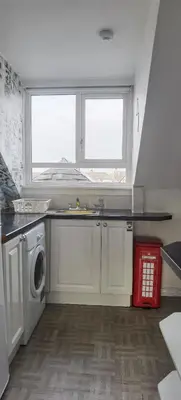 a kitchen with a sink and a washing machine at Quiet Street's Flat with free Parking near Town Centre in Largs