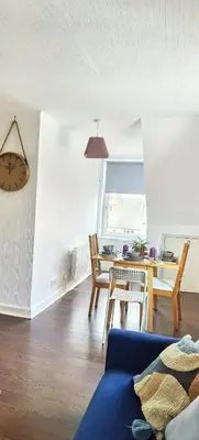 a living room with a blue couch and a table at Quiet Street's Flat with free Parking near Town Centre in Largs