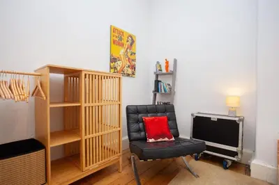 a living room with a chair and a television at Lovely Flat in Ideal Location in Glasgow