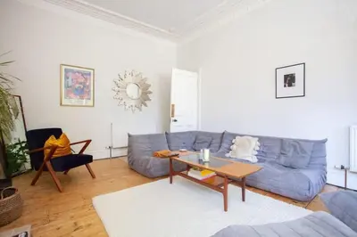 a living room with a blue couch and a table at Lovely Flat in Ideal Location in Glasgow