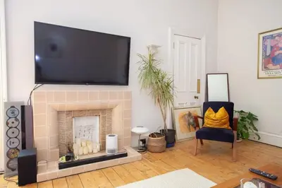 a living room with a fireplace with a flat screen tv at Lovely Flat in Ideal Location in Glasgow
