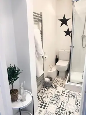 a bathroom with a black and white tile floor at Boutique West End Apartment - 'The Nook' in Glasgow