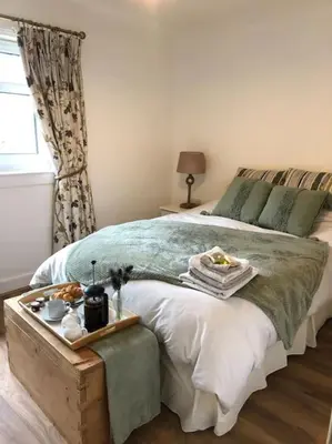 a bedroom with a bed with a tray of food on it at Station House Flat on outskirts of Thornhill in Thornhill