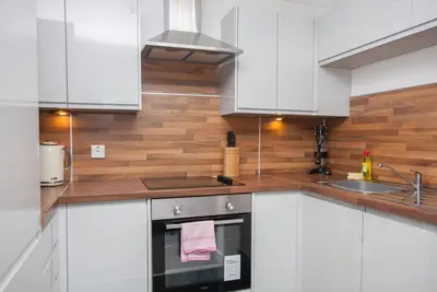 a kitchen with white cabinets and a stove top oven at 3 Bedroom Duplex with Free Parking in Glasgow