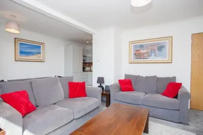 a living room with two gray couches and red pillows at 3 Bedroom Duplex with Free Parking in Glasgow