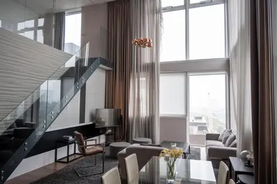 a living room with a glass table and a staircase at Stunning 3 Bed Penthouse in West End in Glasgow