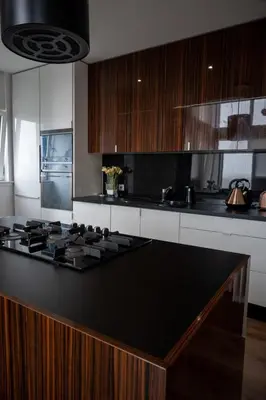 a kitchen with a black counter top and wooden cabinets at Stunning 3 Bed Penthouse in West End in Glasgow