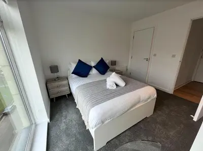 a bedroom with a bed with blue and white pillows at Stylish Newly Decorated 2 Bed in Glasgow