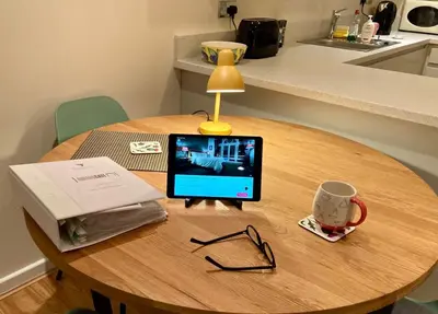 a laptop computer sitting on top of a wooden table at The Art Flat Woodlands in Glasgow