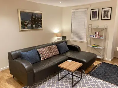 a living room with a leather couch and a table at The Art Flat Woodlands in Glasgow