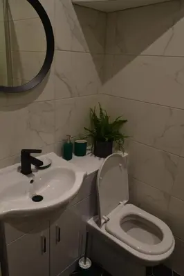 a bathroom with a sink and a toilet and a mirror at 2 Bedroom Oasis in Glasgow City Centre in Glasgow