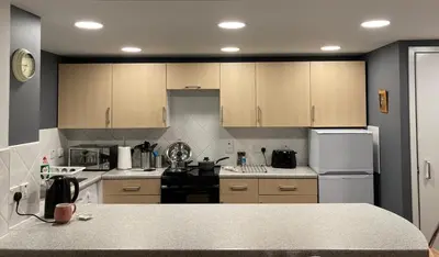 a kitchen with wooden cabinets and a counter top at The Art Flat Glasgow in Glasgow