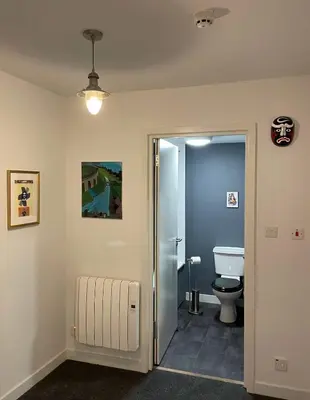 a bathroom with a toilet and a glass door at The Art Flat Glasgow in Glasgow