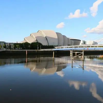 a bridge over a body of water in front of a stadium at Stunning Flat in West End Location in Glasgow