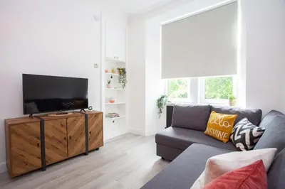 a living room with a couch and a flat screen tv at Stunning Flat in West End Location in Glasgow