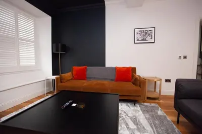 a living room with a couch and a coffee table at Charming Sandstone-Basement Apartment in West End in Glasgow