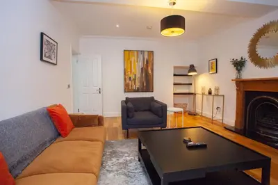 a living room with a couch and a coffee table at Charming Sandstone-Basement Apartment in West End in Glasgow