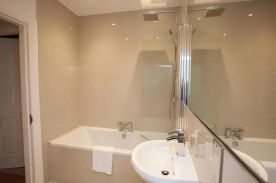a bathroom with a sink and a bath tub at Charming Sandstone-Basement Apartment in West End in Glasgow