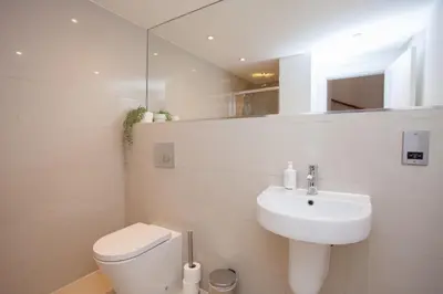 a white bathroom with a toilet and a sink at Charming Sandstone-Basement Apartment in West End in Glasgow