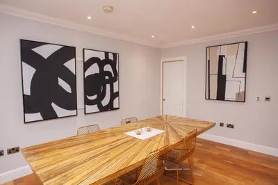 a dining room with a wooden table with chairs at Charming Sandstone-Basement Apartment in West End in Glasgow