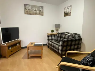 a living room with a couch and a tv at Pure East Coast Trainline by TBA in Fife