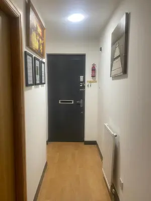 a black door in a hallway with pictures on the wall at Pure East Coast Trainline by TBA in Fife