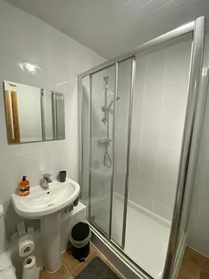 a white bathroom with a shower and a sink at Pure East Coast Trainline by TBA in Fife