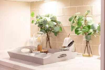 a bathroom counter with a white sink and flowers at The Bradshaw in Prestwick