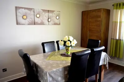 a dining room table with a vase of flowers on it at Double Room in Riverside Apartment - C in Glasgow