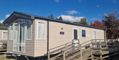 a mobile home with a porch and a deck at Lochgilphead Caravan Park in Lochgilphead