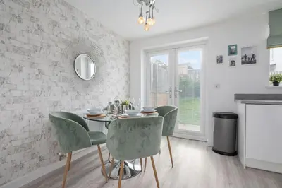 a dining room with a table and green chairs at 3BDR House By Vista Stays Short Lets & Serviced Accommodation Glasgow Scotland With Driveway Parking and PS4 in Glasgow