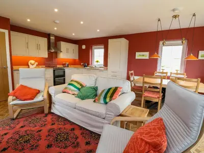 a living room with a couch and a kitchen at Tirlaggan Úr in Oban