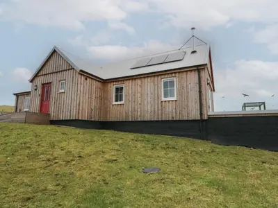 a house with a solar roof on top of a field at Tirlaggan Úr in Oban