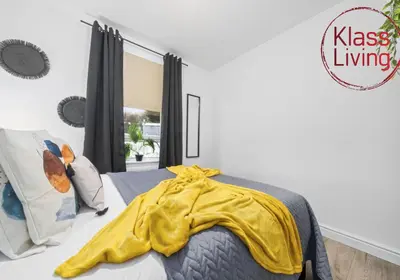 a bedroom with a yellow blanket on a bed at Drumpellier Apartment by Klass Living Coatbridge in Coatbridge