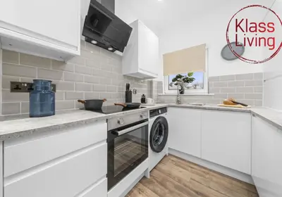 a white kitchen with a washer and dryer at Drumpellier Apartment by Klass Living Coatbridge in Coatbridge