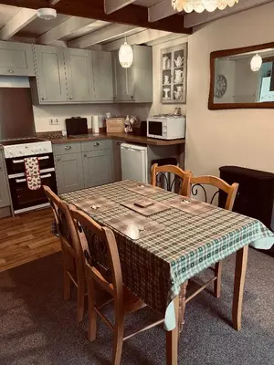 a kitchen with a table and some chairs and a kitchen with a table at Lazy Days in Moffat
