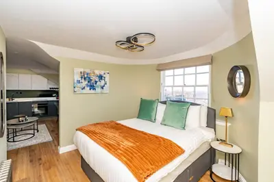 a bedroom with a large bed with green pillows at Dragon Suites Luxury Apartments at 9 Albyn Place in Edinburgh