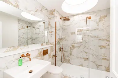 a white bathroom with a sink and a shower at Dragon Suites Luxury Apartments at 9 Albyn Place in Edinburgh
