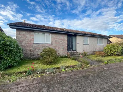 a brick house on the side of a road at Kiloran in Oban